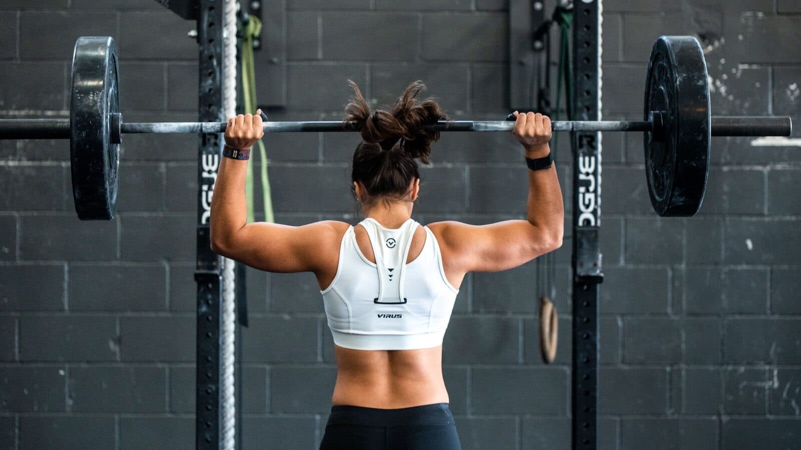 Vrouw die krachttraining doet met een barbell