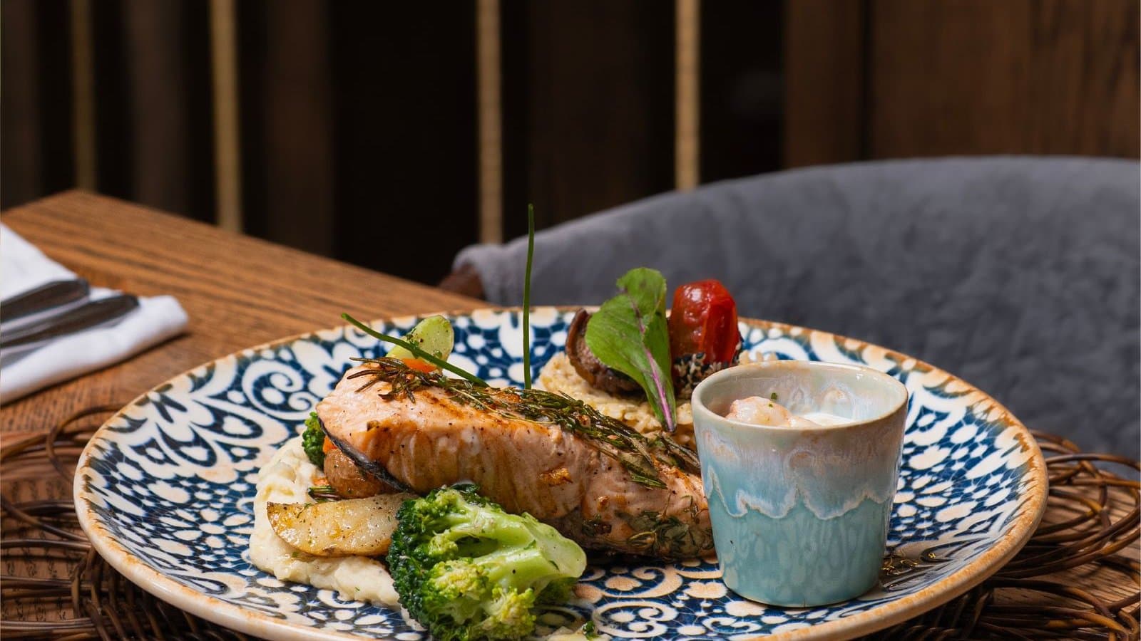 Gegrilde zalm met broccoli op een bord aan een houten tafel — voeding levert meer dan één stof tegelijk